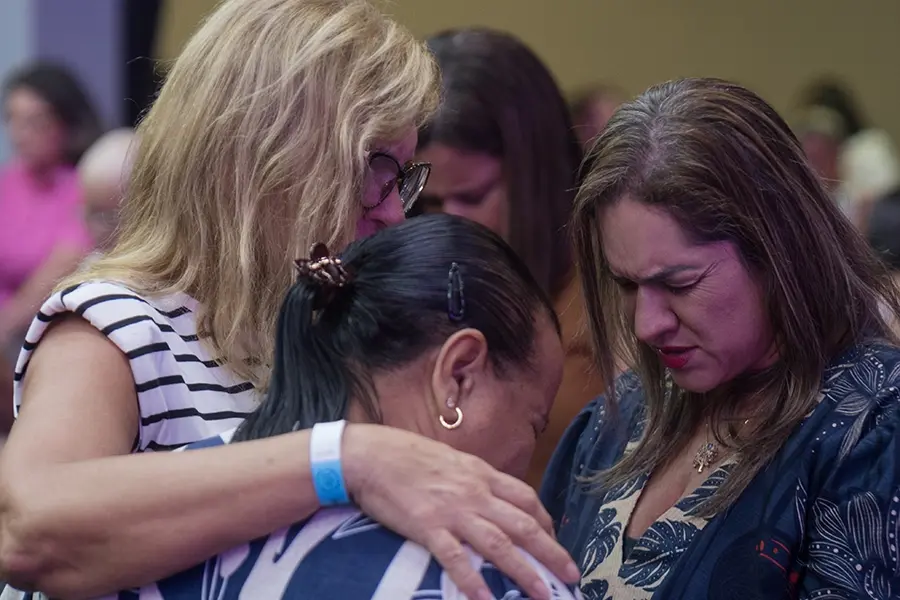 Women praying together at the conference in Brazil